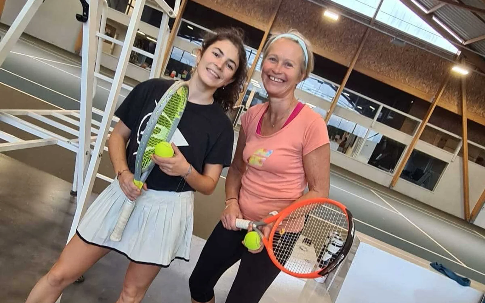 Deux joueuses de tennis sur un court couvert du club