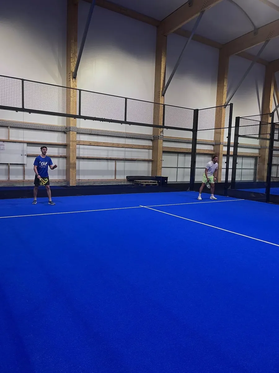 Joueurs sur une piste de padel couverte du club