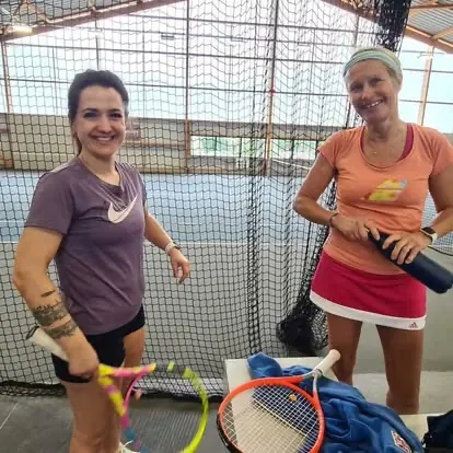 Deux joueuses de padel sur un court couvert du club